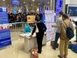 Khách đứng giãn cách khi làm thủ tục tại sân bay để phòng COVID-19