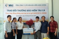 Bà Hà Thị Thu Trang - Giám đốc VNI Quảng Ngãi trao số tiền bồi thường tàu cá cho chủ tàu Võ Văn Dũng.