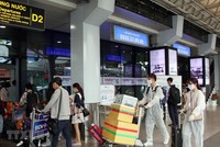 Để phòng chống dịch, nhiều hành khách đã chủ động trang bị các bộ đồ bảo hộ khi đến sân bay Tân Sơn Nhất. (Ảnh: Tiến Lực/TTXVN).