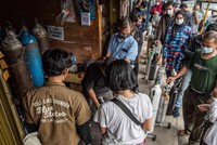 Người nhà của bệnh nhân Covid-19 xếp hàng để bơm đầy bình oxy ở Manggarai, Jakarta. Ảnh: Shutterstock.