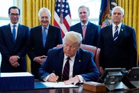 Tổng thống Mỹ Donald Trump ký gói cứu trợ Covid-19 tại Nhà Trắng ngày 27/3. Phía sau từ trái qua bao gồm Bộ trưởng Tài chính Steven Mnuchin, Lãnh đạo đa số tại Thượng viện Mitch McConnell, Lãnh đạo thiểu số tại Hạ viện Kevin McCarthy và Phó Tổng thống Mike Pence. Ảnh: AP.