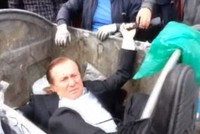 Nghị sĩ Vitaly Zhuravsky bị đám đông ném vào thùng rác (Nguồn: DM)