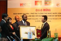 Ông Đỗ Quang Hiển – Chủ tịch HĐQT SHB tặng quà lưu niệm cho ông Henry Kajura – Phó Thủ tướng Thứ nhất Nước Cộng hòa Uganda