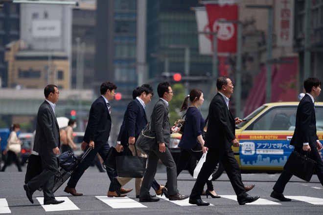 Nhân viên công sở đi bộ đến nơi làm việc ở Tokyo. Ảnh: Japan Times.