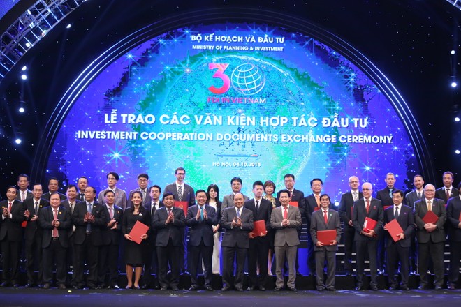 Thủ tướng Nguyễn Xuân Phúc, Phó thủ tướng Vương Đình Huệ và lãnh đạo bộ, ngành, địa phương chụp ảnh lưu niệm với các nhà đầu tư nước ngoài được cấp giấy chứng nhận đầu tư tại Hội nghị 30 năm thu hút FDI