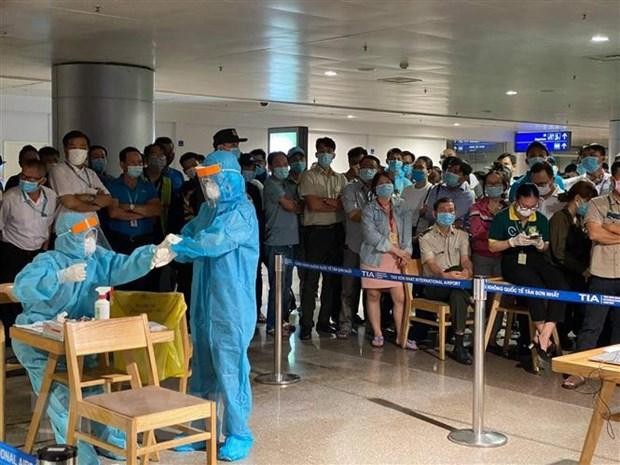 Nhân viên y tế làm thủ tục lấy mẫu xét nghiệm cho người làm việc tại sân bay Tân Sơn Nhất. (Ảnh: TTXVN phát).