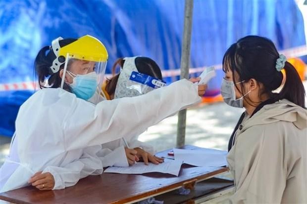 Nhân viên y tế đo thân nhiệt cho người dân trước khi tiêm vaccine, tại Đà Nẵng. (Ảnh: Văn Dũng/TTXVN).