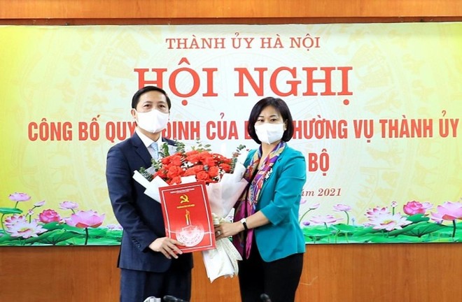 Phó Bí thư Thường trực Thành ủy Nguyễn Thị Tuyến trao quyết định, tặng hoa chúc mừng ông Nguyễn Thanh Liêm.