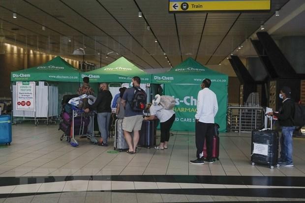 Hành khách xếp hàng chờ xét nghiệm COVID-19 tại sân bay quốc tế OR Tambo ở Johannesburg, Nam Phi. (Ảnh: AFP/TTXVN).