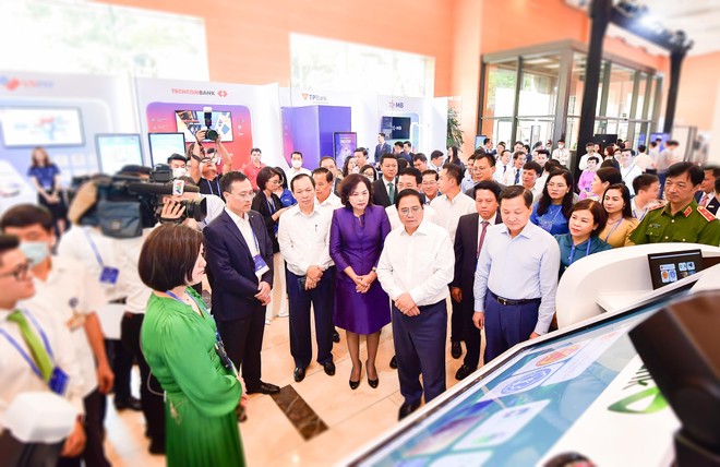 Ban Lãnh đạo Vietcombank giới thiệu về sản phẩm dịch vụ của Vietcombank với đoàn đại biểu do Thủ tướng Chính Phủ Phạm Minh Chính (hàng đầu thứ hai từ phải sang) dẫn đầu tại sự kiện
