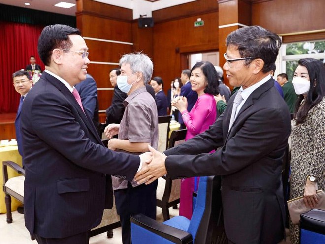 Chủ tịch Quốc hội Vương Đình Huệ (bên trái) gặp gỡ người Việt Nam tại Lào.