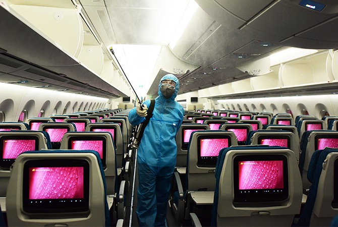 Phun khử trùng trên máy bay Vietnam Airlines ngày 24/3. Ảnh: Giang Huy.