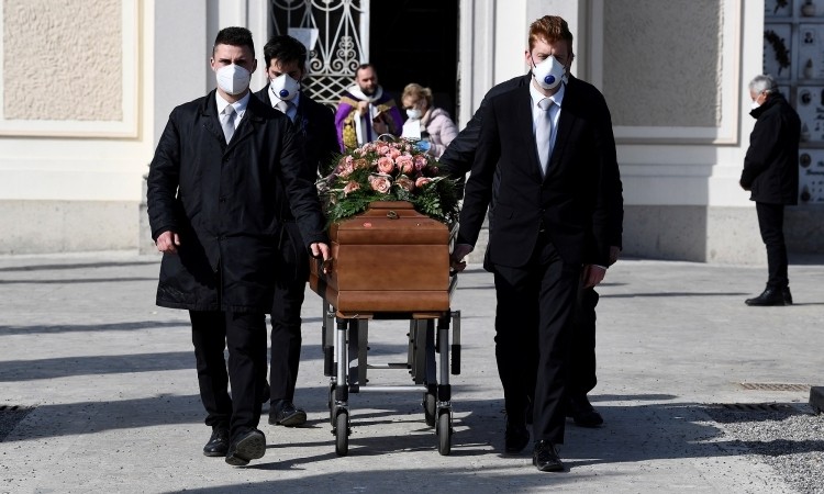 Nhóm người khiêng linh cữu đeo khẩu trang tại đám tang của một phụ nữ chết do nCoV ở Seriate. Italy, hôm 28/3. Ảnh: Reuters. 