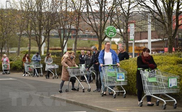 Người dân xếp hàng chờ mua sắm bên ngoài một siêu thị ở Gateshead, Anh. (Ảnh: AFP/TTXVN).