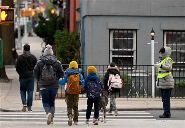 Học sinh tới lớp học sau khi trường học mở cửa trở lại tại New York , Mỹ. (Ảnh: AFP/TTXVN)