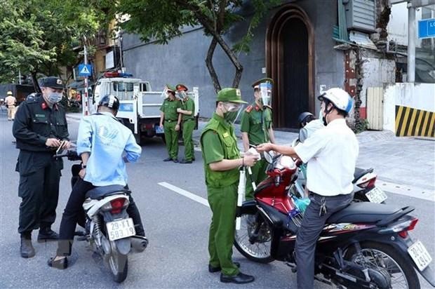 Lực lượng Công an Hà Nội kiểm tra giấy tờ của người tham gia giao thông tại chốt liên ngành tuyến phố Trần Quang Khải (quận Hoàn Kiếm). (Ảnh: Phạm Kiên/TTXVN).