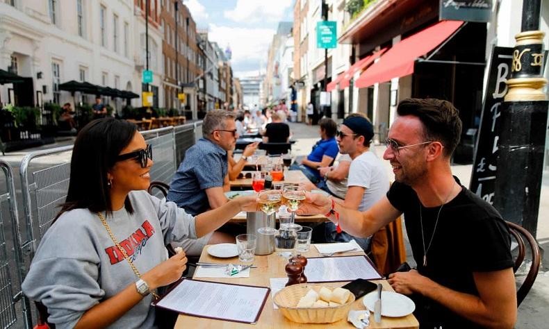 Thực khách thưởng thức đồ uống tại một nhà hàng ở London, hưởng ứng chương trình kích cầu EOHO của chính phủ Anh. Ảnh: AFP 