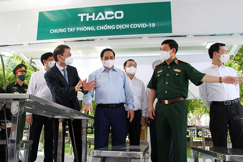 Doanh nhân Trần Bá Dương (hàng đầu, bên trái) giới thiệu xe chuyên dụng tiêm chủng với Thủ tướng Chính phủ Phạm Minh Chính